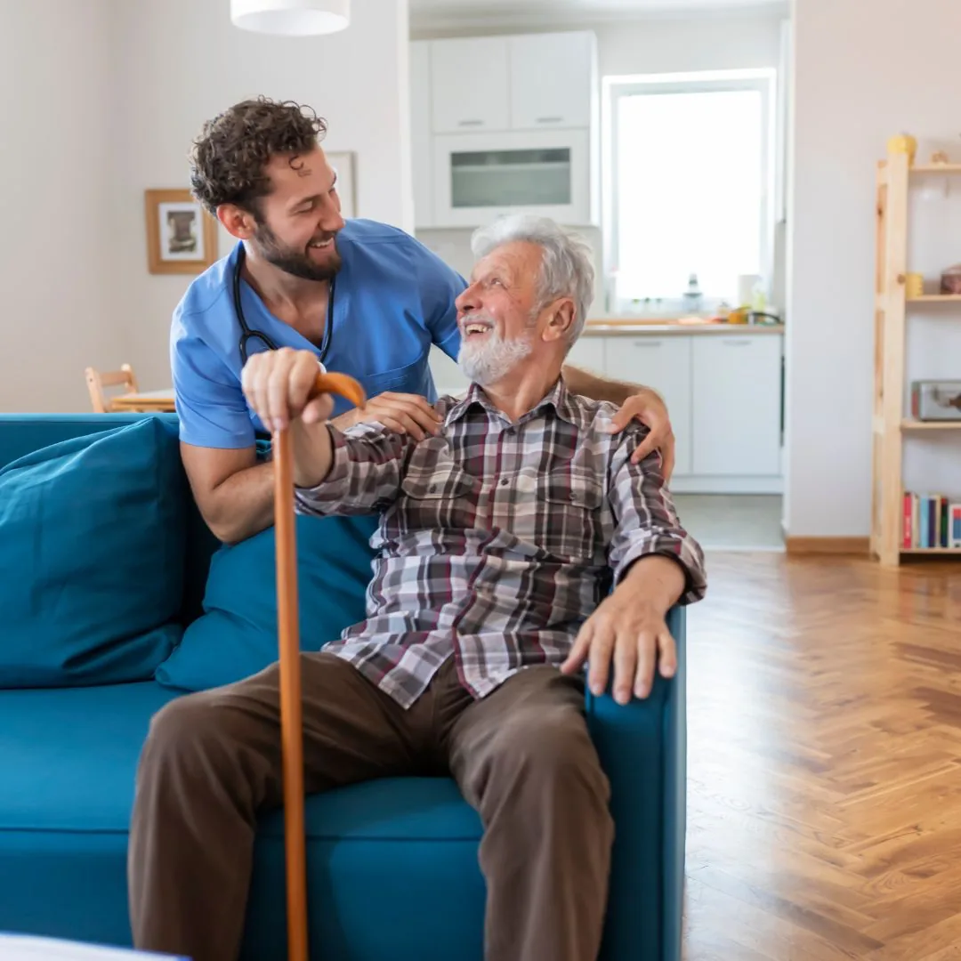 Médico acompanhando um idoso na sala de casa, os dois conversando
